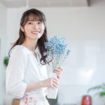 花を花瓶に入れて持ち歩く女性